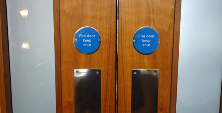 Technician conducting thorough fire door inspection to ensure compliance and safety standards.