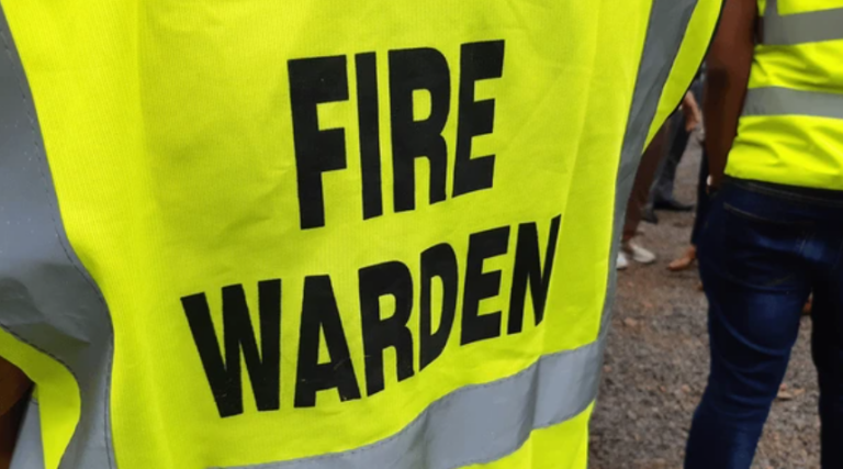 Fire Warden in yellow high-visibility vest overseeing safety procedures.